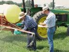 Two men calibrating boom sprayer.