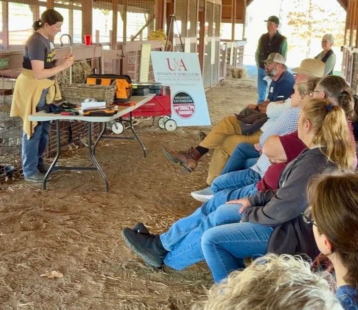 Woman speaking in a barn to a crowd