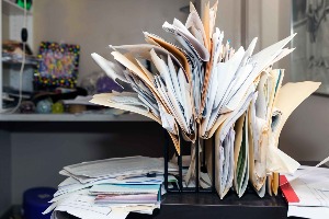 Picture of desk cluttered with papers and file folders with papers  