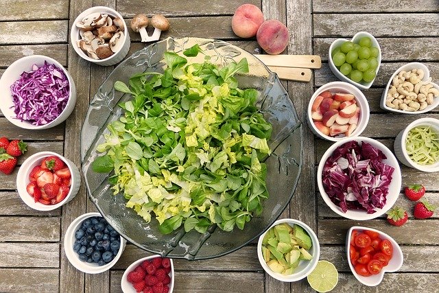 big bowl of lettuce surrounded by smaller bowls of other individual salad ingredients
