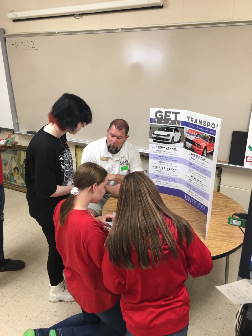 adult and students looking at display on transportation