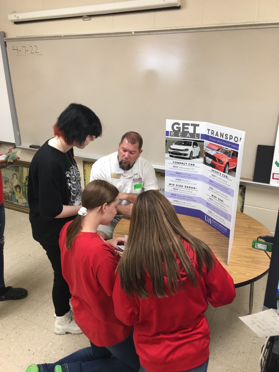 adult and students looking at display on transportation