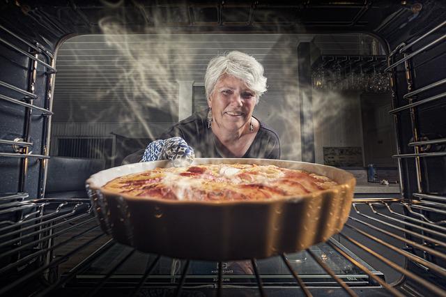 women taking dish out of oven