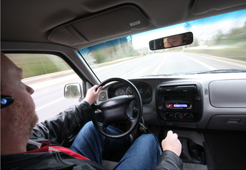 Man driving distracted by hands-free cell phone use.