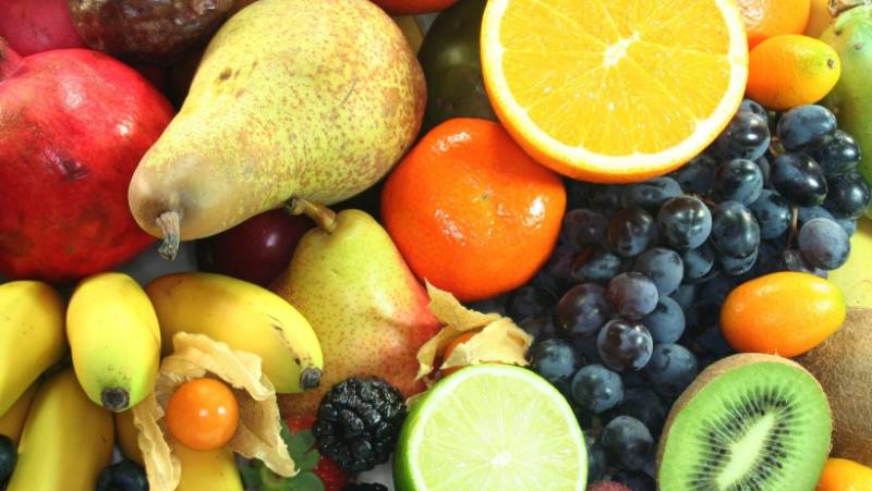 Assortment of fruit as an example of what can be included in fruit infused water. The fruit pictured contains berries, grapes, oranges, limes, pears, kumquats, and kiwi.