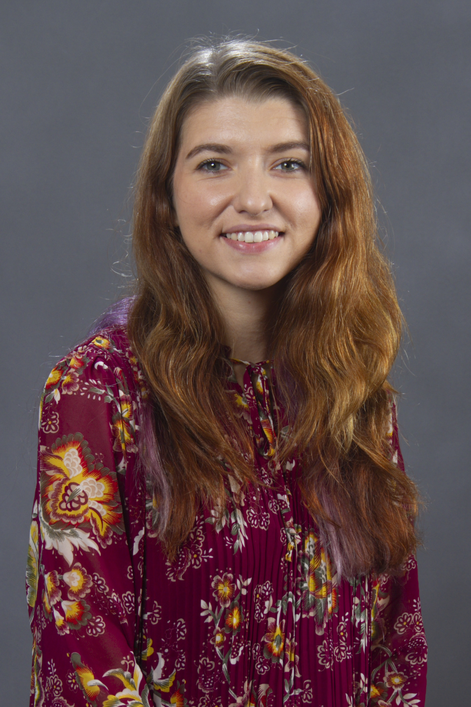 Nancy Hightower - a young woman with auburn hair and a maroon dress smiling