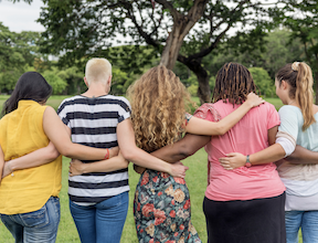 a group of women facing away from the camera with their arms around each other's backs