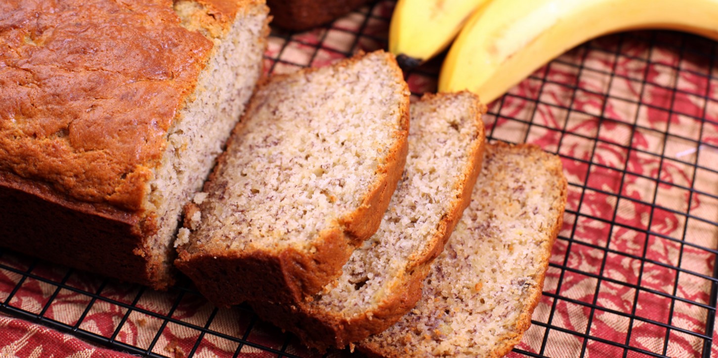 loaf of banana bread sliced on cutting board