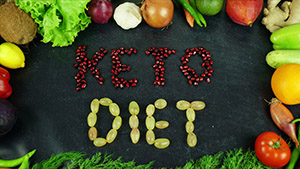 Keto Diet spelled out using fruits and beans with veggies on the edge of the image