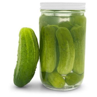 Quart size jar of bright green cucumbers being pickled.