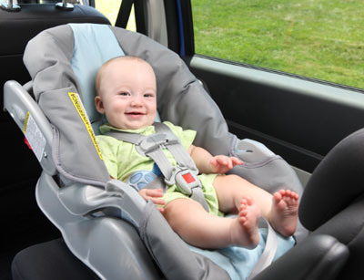 Baby under 2 in rear-facing car seat with properly secured straps