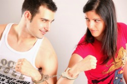 man and woman staring at each other with one of their arms handcuffed to each other
