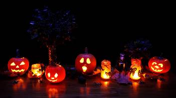 Halloween pumpkins and candles on ground