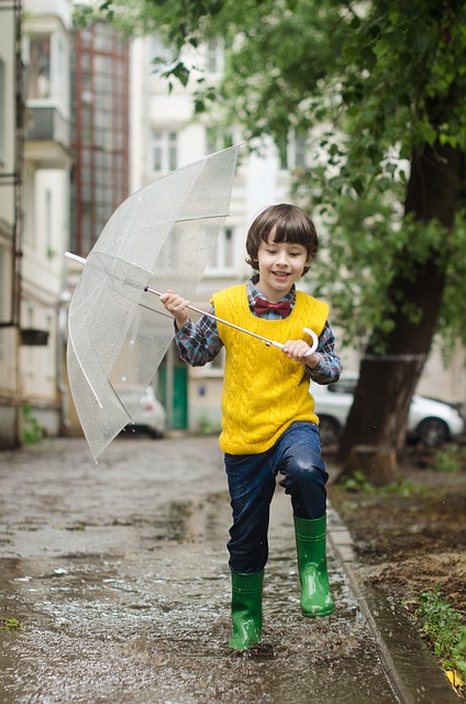 young boy holding umbrella in the rain