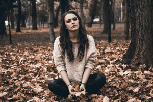 Girl sitting on ground with a sad face