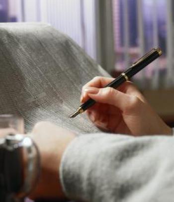 Hands holding a newspaper and ink pen while checking on stocks.