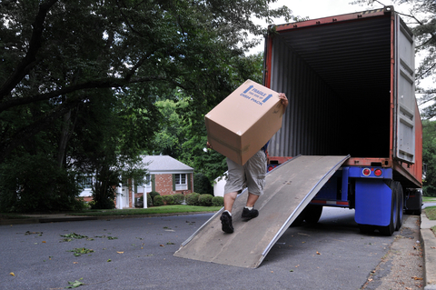 man carrying a large box into a moving truck