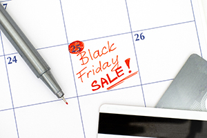 calculator and credit card on top of a calendar marked with Friday as black friday