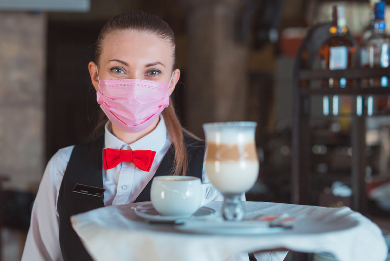 Waiter with mask and tray of food. 