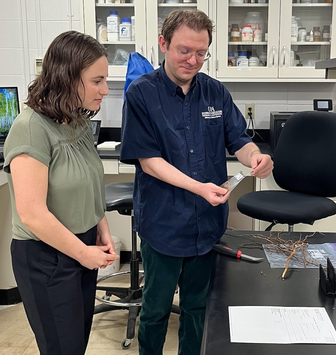 Taylor Klass (left) and Jason Pavel (right) examining an ImmunoStrip® test for Phytophthora rot.